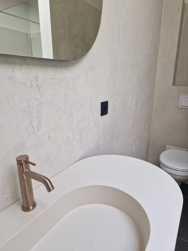 Salle de bain en Mortex beige clair sur sol et murs, vasque design et robinetterie cuivrée, réalisation Sol Color
