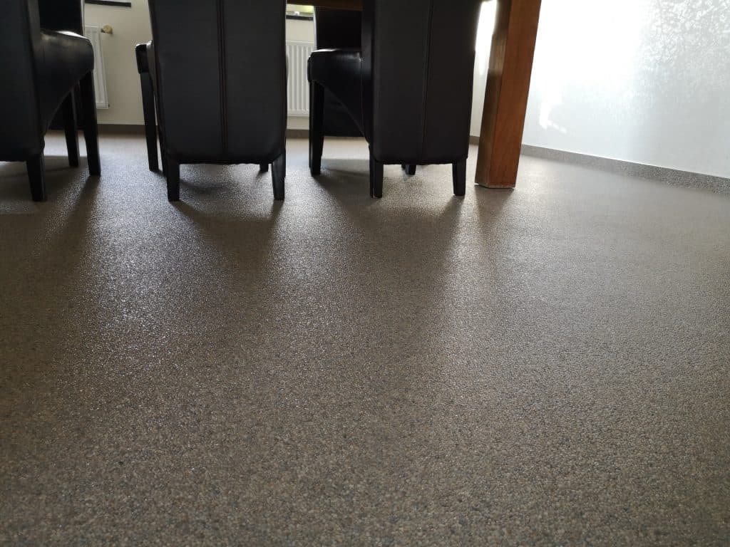 Salle à manger avec sol en tapis de pierres taupe satiné, chaises en cuir noir, Sol Color