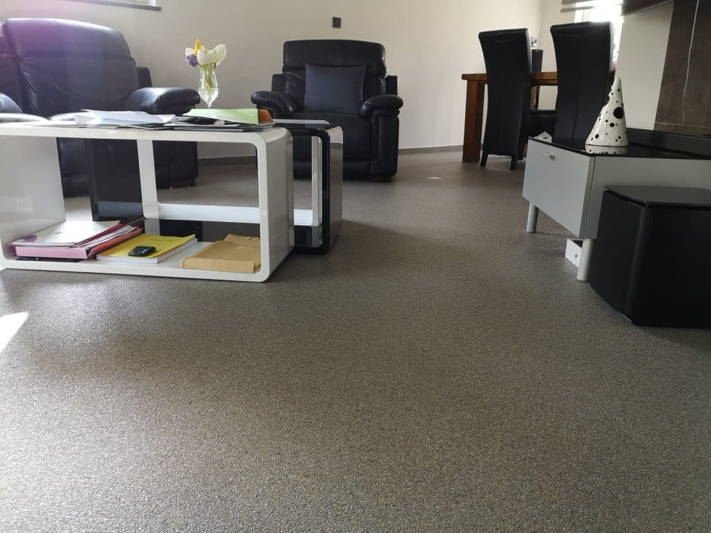 Salon avec sol en tapis de pierres gris beige, fauteuils en cuir et table basse design, Sol Color